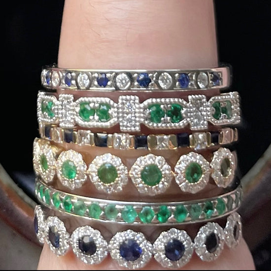 stacked vintage rings with sapphires, diamonds, and emeralds in gold/silver
