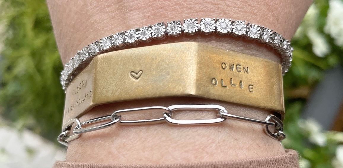 Bracelet stack: diamond tennis bracelet, brass cuff, silver chain link bracelet