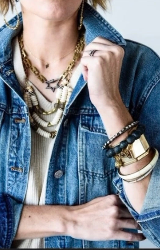woman styled with stacked necklaces and bracelets 